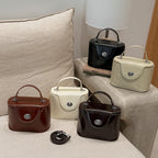 Damen Mini-Handtasche im elegant geschwungenen Design mit spielerischem Anhänger