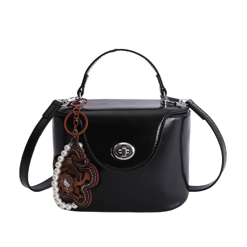 Damen Mini-Handtasche im elegant geschwungenen Design mit spielerischem Anhänger
