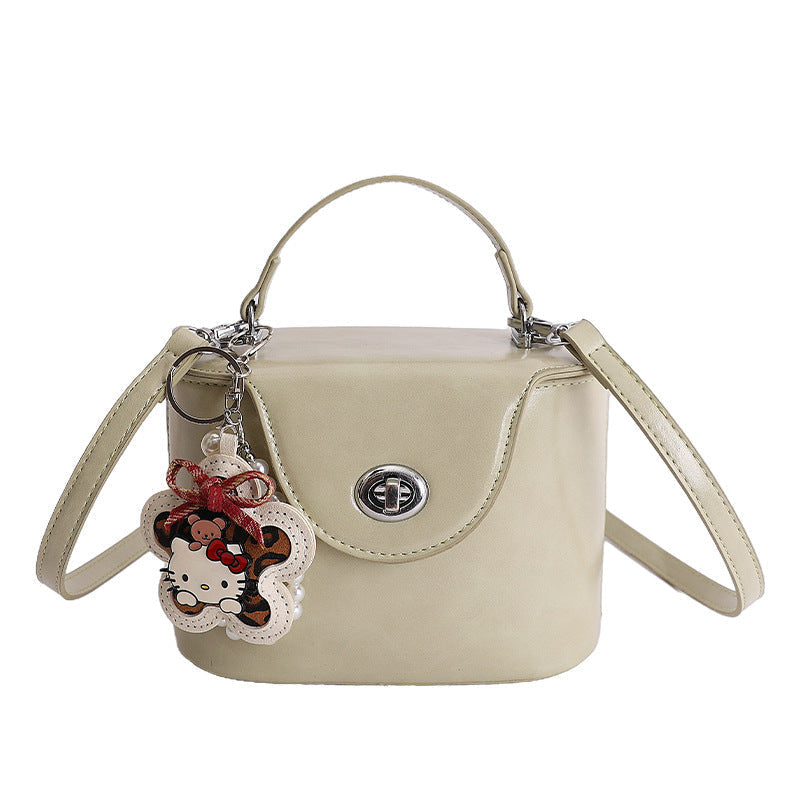 Damen Mini-Handtasche im elegant geschwungenen Design mit spielerischem Anhänger