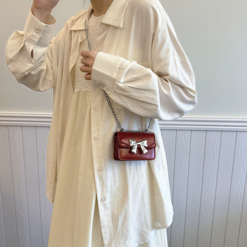 Damen Mini-Handtasche mit schimmerndem Schleifenverschluss