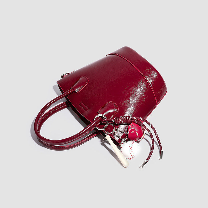 Damen Mini Tasche mit glänzender Oberfläche und verspieltem Anhänger