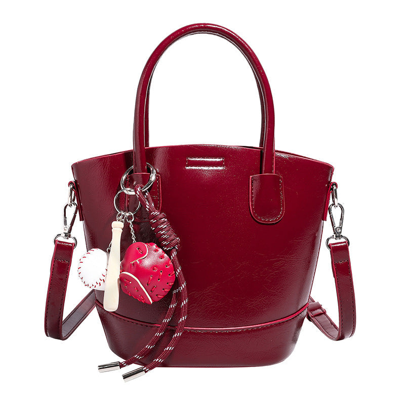 Damen Mini Tasche mit glänzender Oberfläche und verspieltem Anhänger